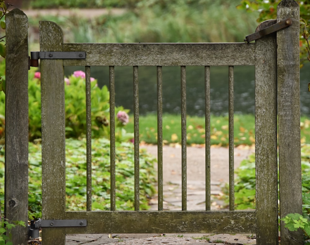 a wooden gate with a bird perched on top of it