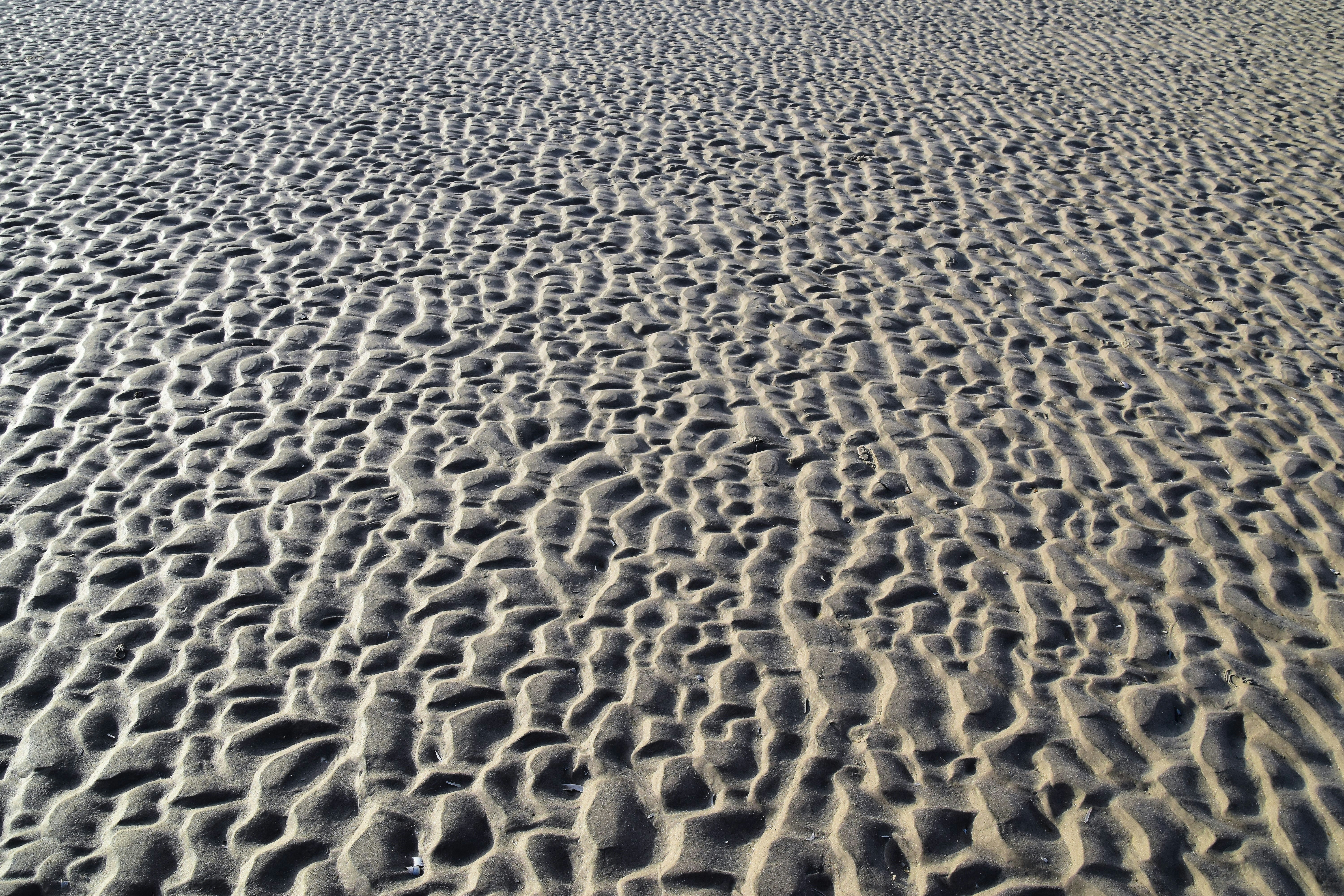 a sandy beach with footprints in the sand