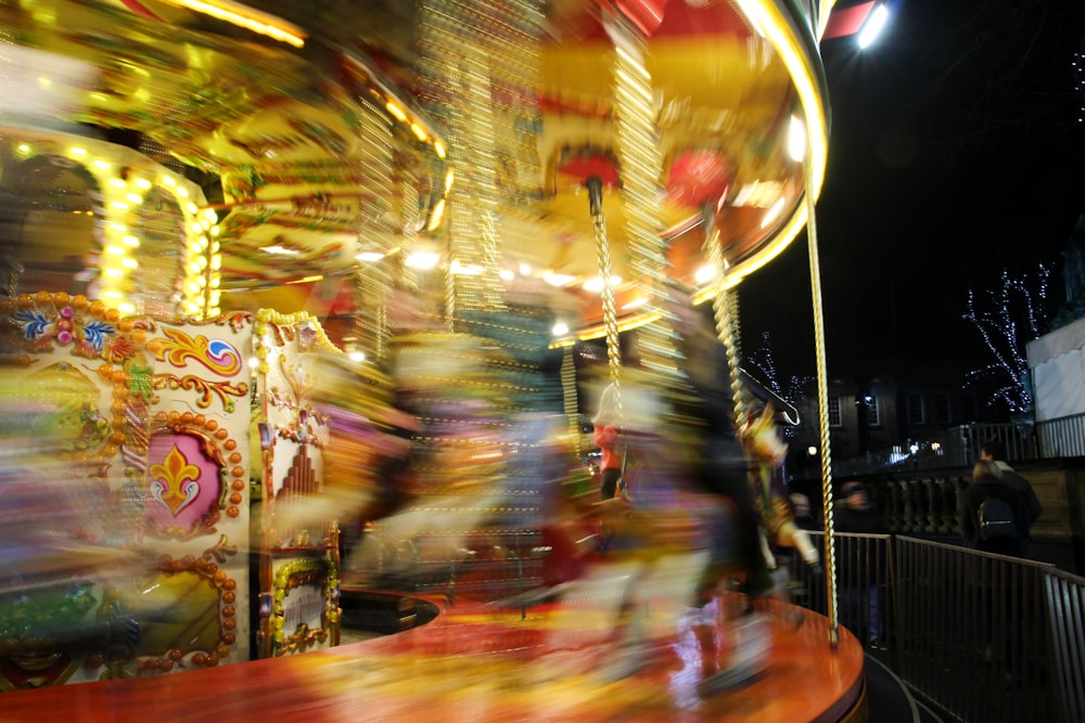 une photo floue d’un manège de carnaval la nuit