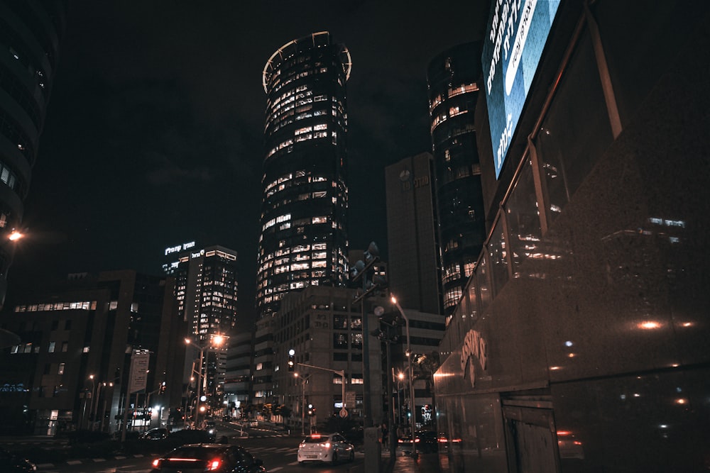 a city street at night with a lot of tall buildings