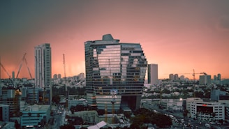 A modern Riyadh skyline at sunset highlighting new real estate developments with cranes and construction in progress.
