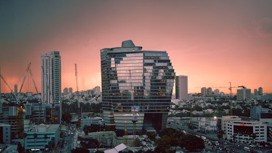 A sleek modern Dubai skyline with cranes and new buildings under construction at sunset.