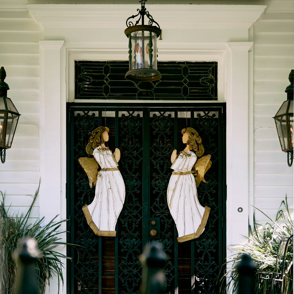 a pair of angel statues on the front door of a house