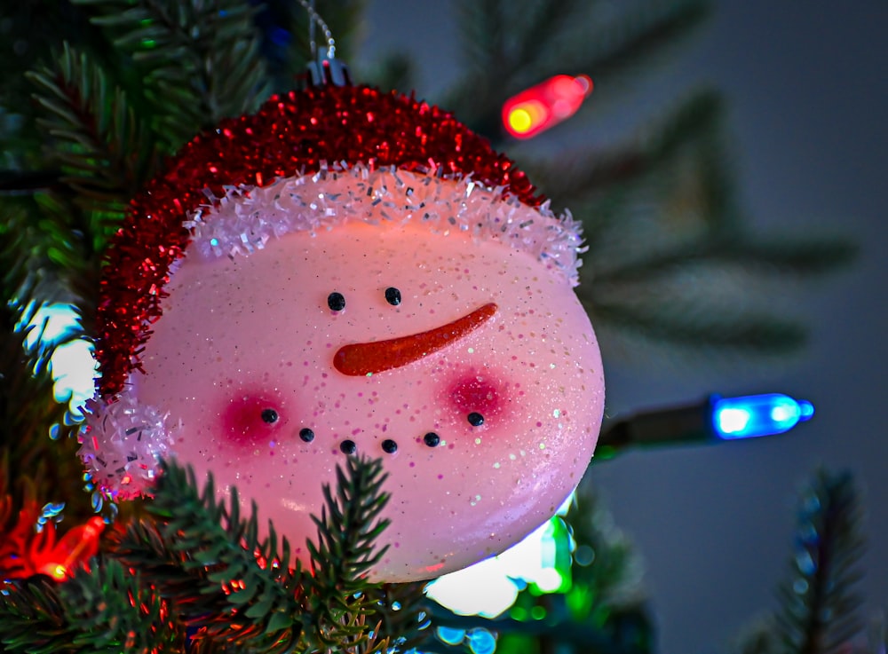 a snowman ornament hanging from a christmas tree