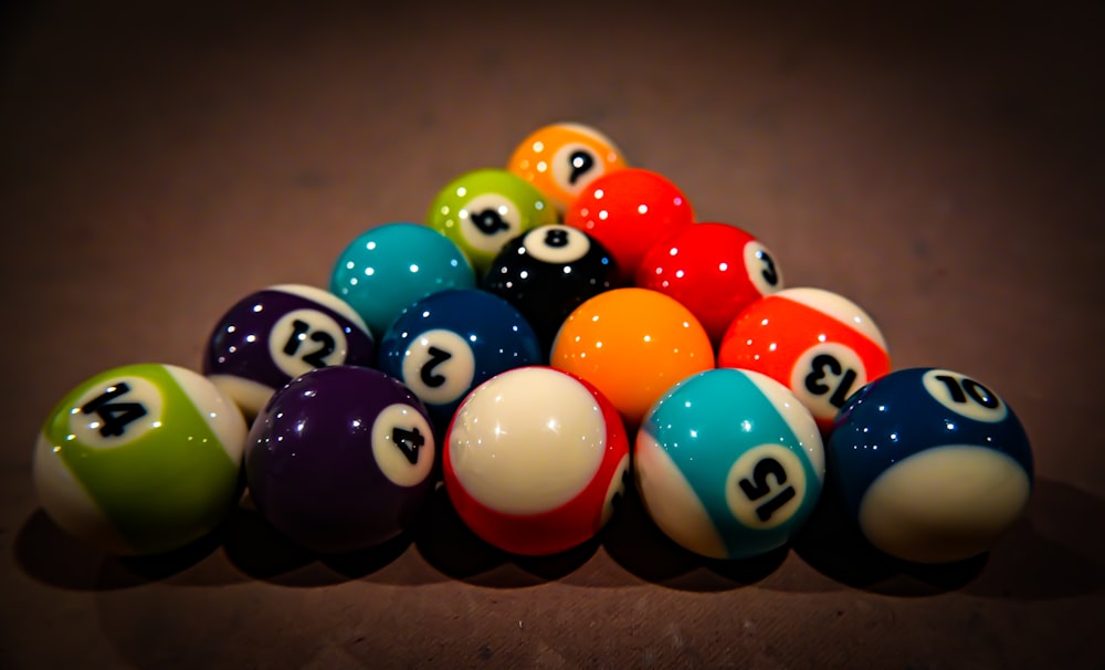 a pile of pool balls sitting on top of a table