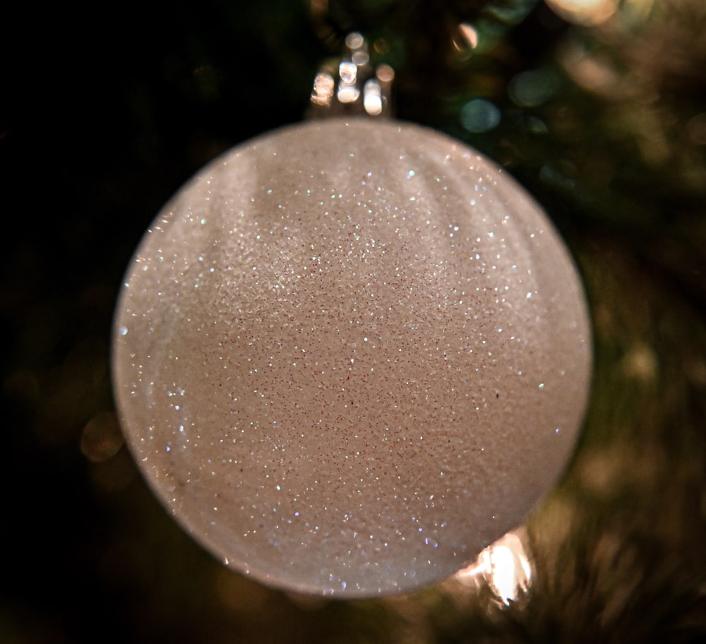 a white ornament hanging from a christmas tree