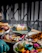 A vibrant spread of colorful dishes beautifully arranged on a rustic wooden table at a lively birthday celebration.