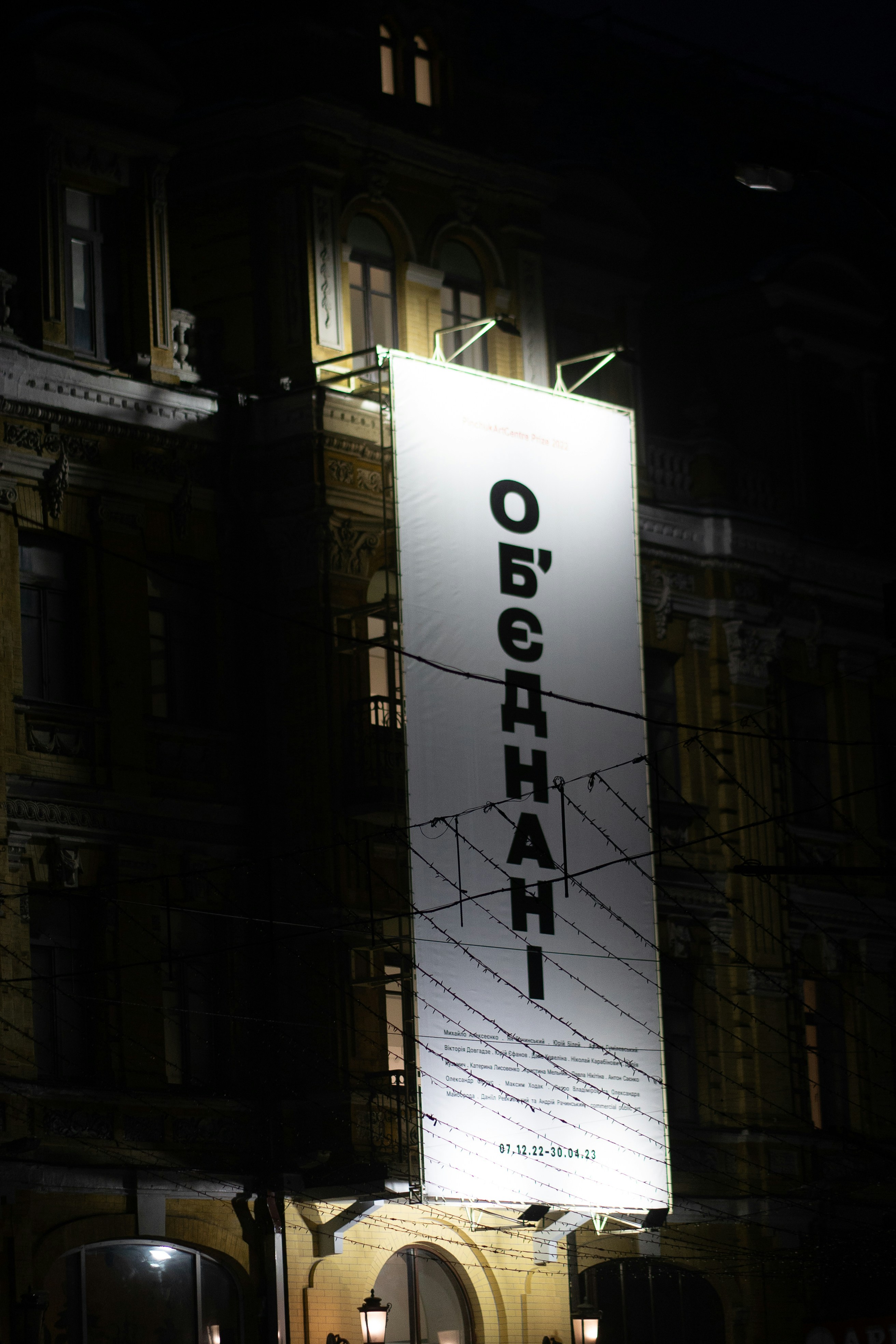 a large white sign hanging from the side of a building