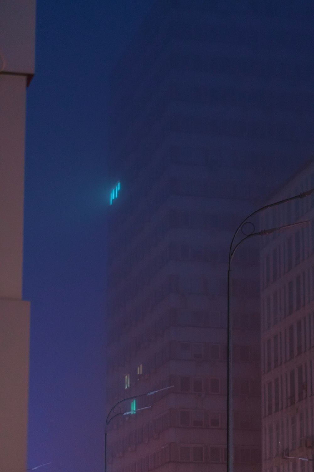 a city street at night with tall buildings