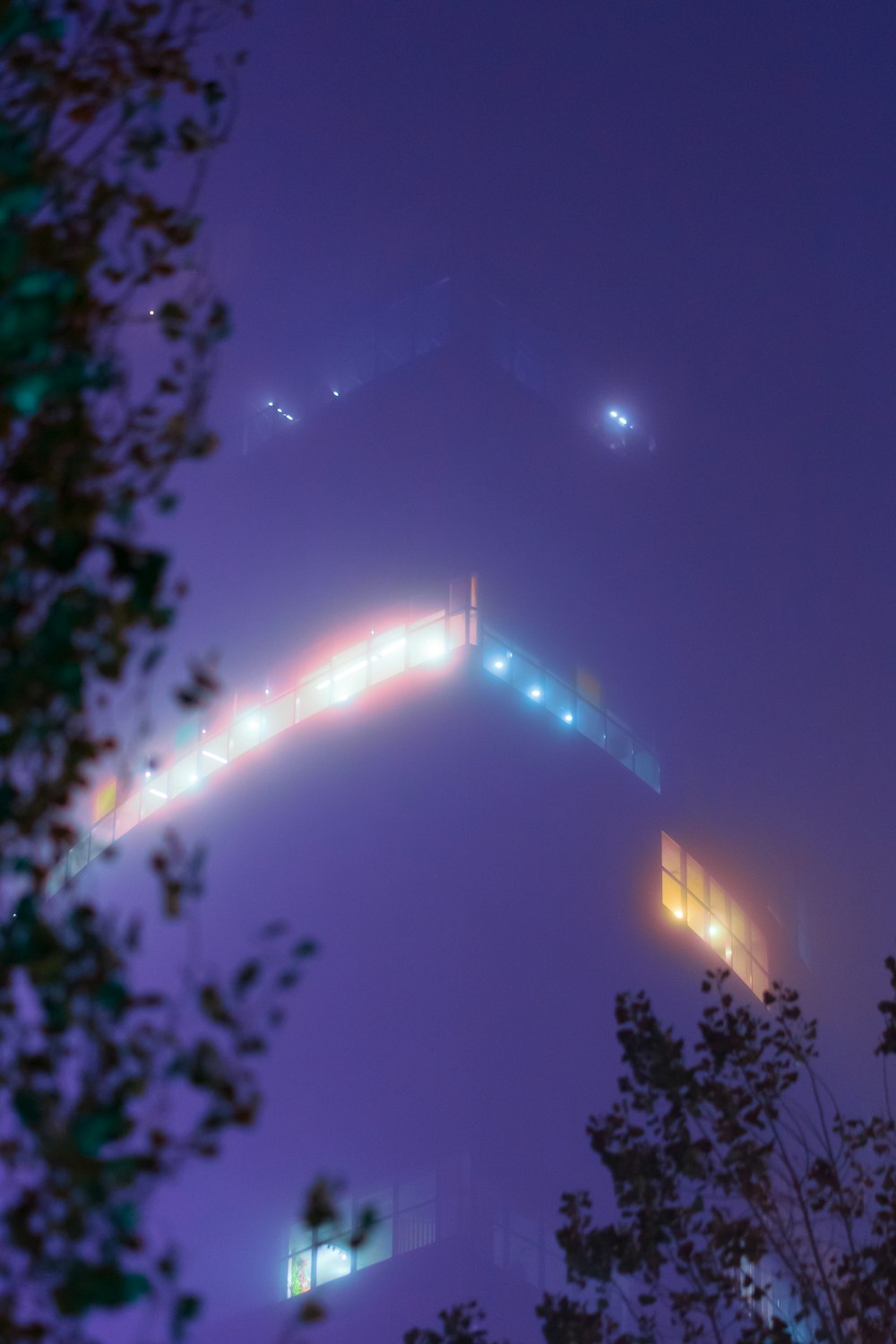 a foggy night with lights on the top of a hill