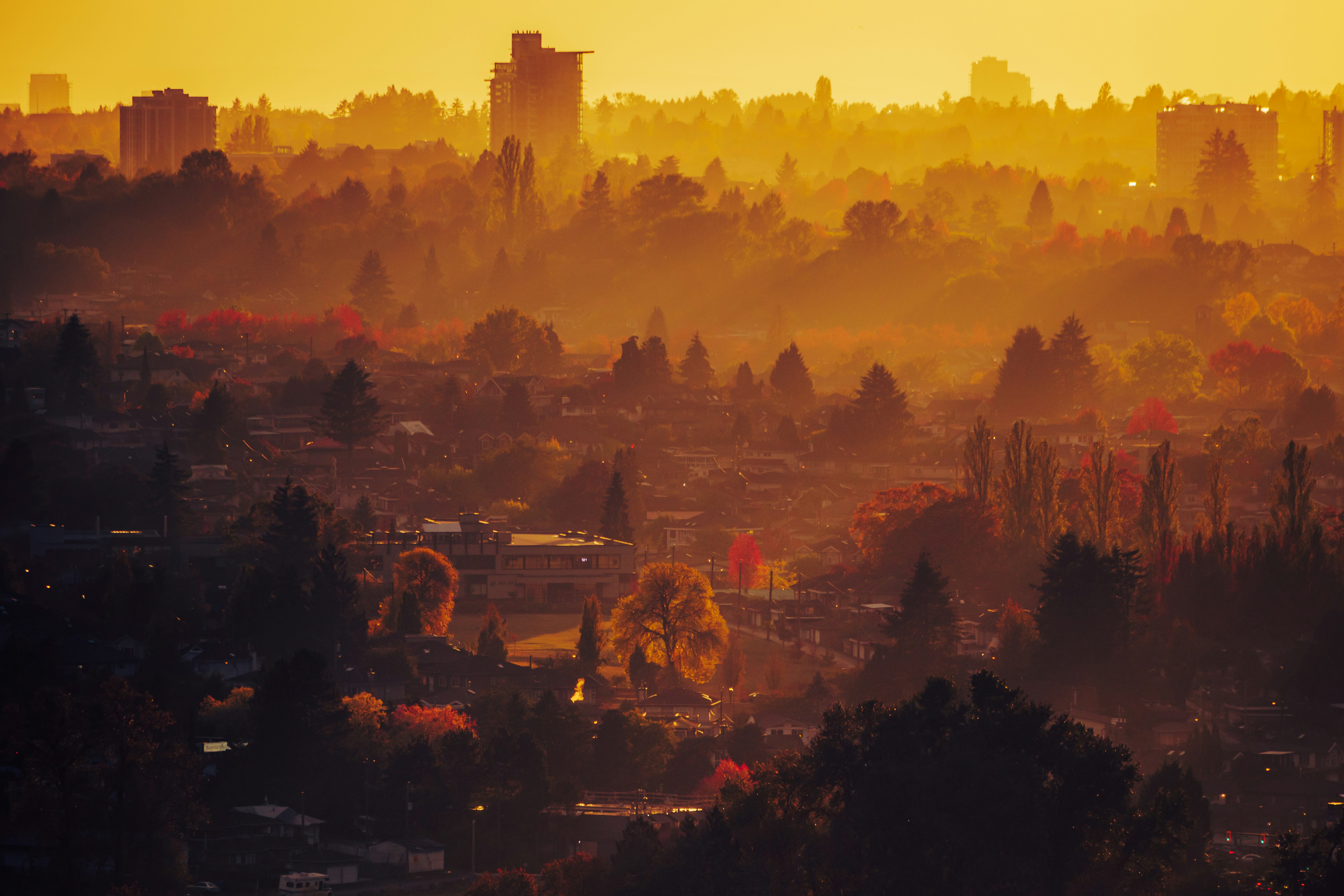 a view of a city at sunset from a hill