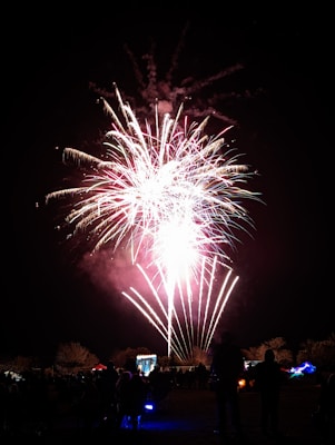 A festive outdoor celebration with fireworks illuminating the sky.