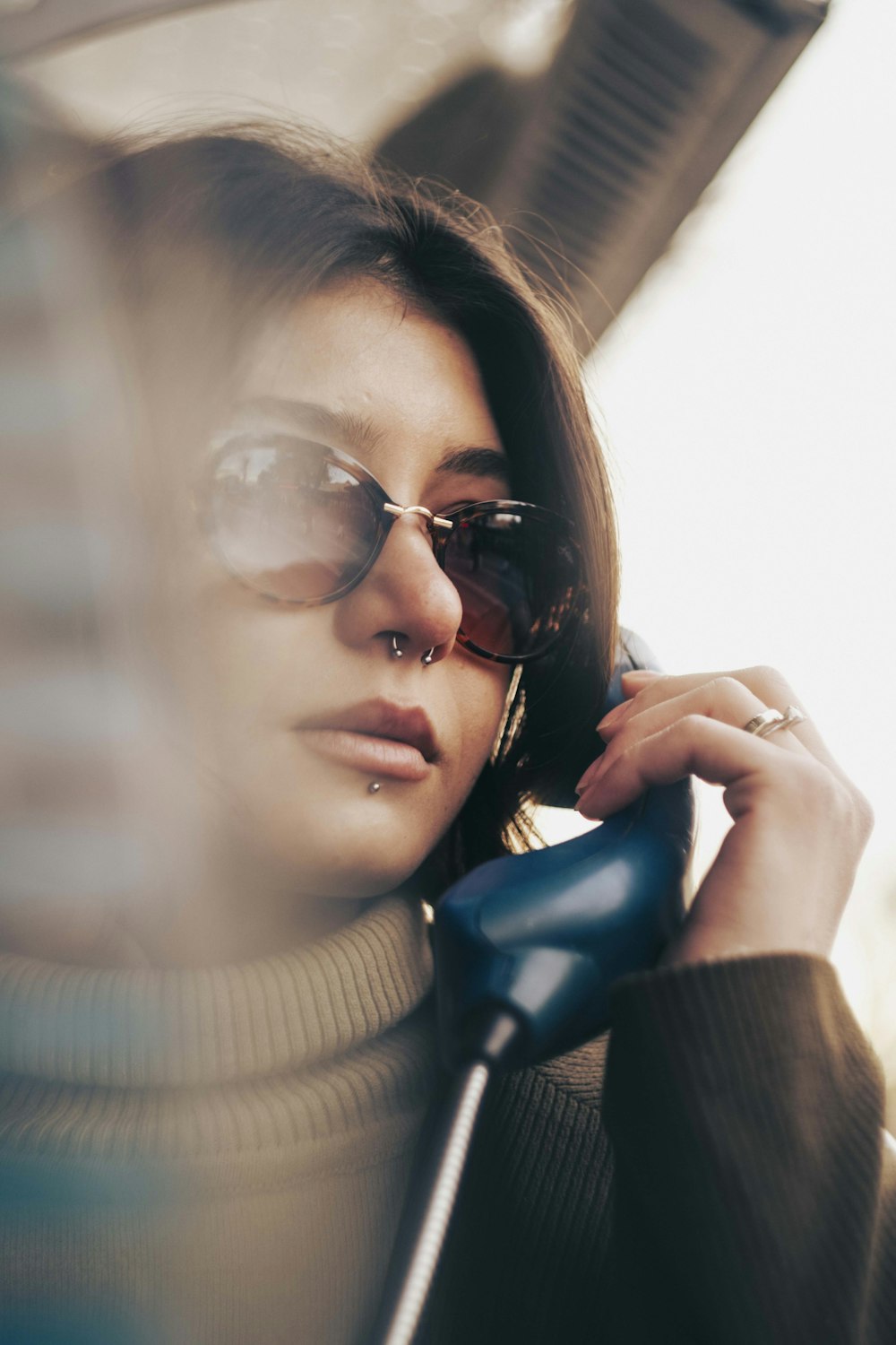 a woman wearing sunglasses talking on a cell phone