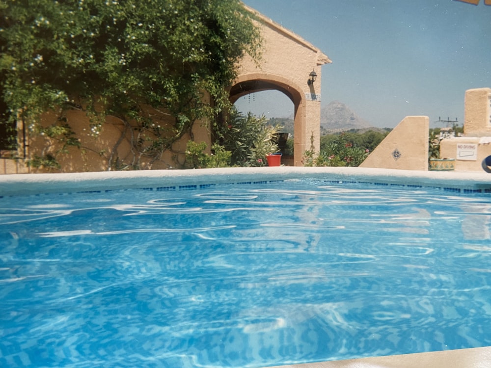 a blue swimming pool with a view of a building