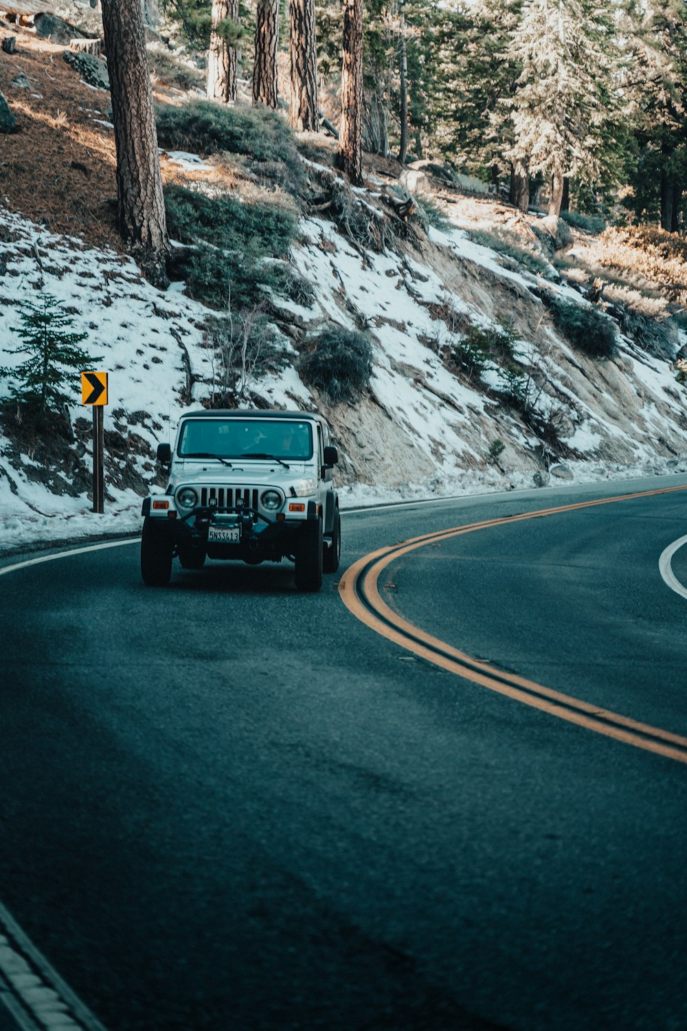 a jeep driving down the road in the snow