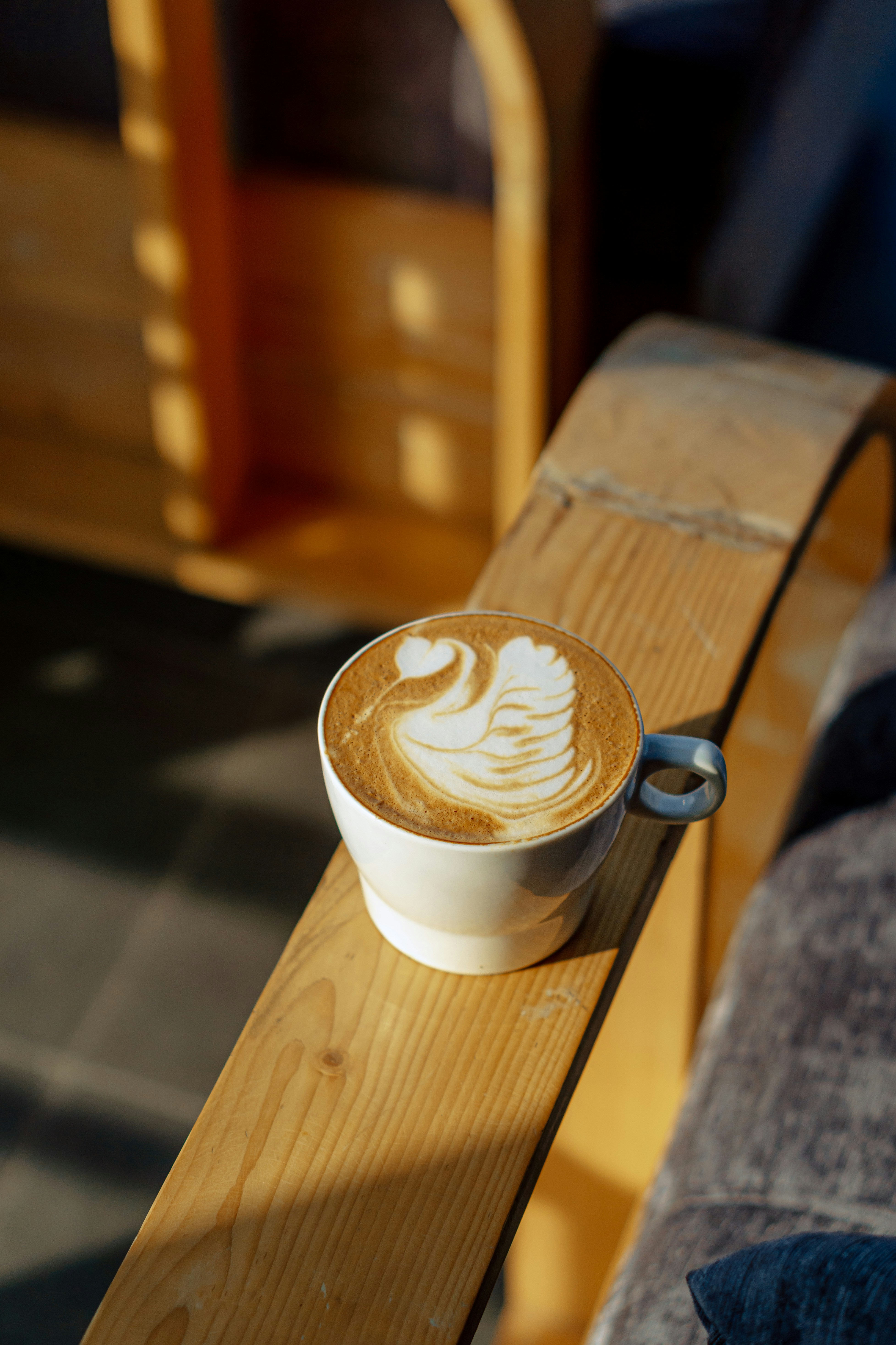 a cup of cappuccino on a wooden table