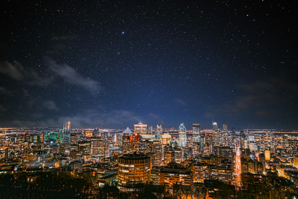 a view of a city at night with stars in the sky