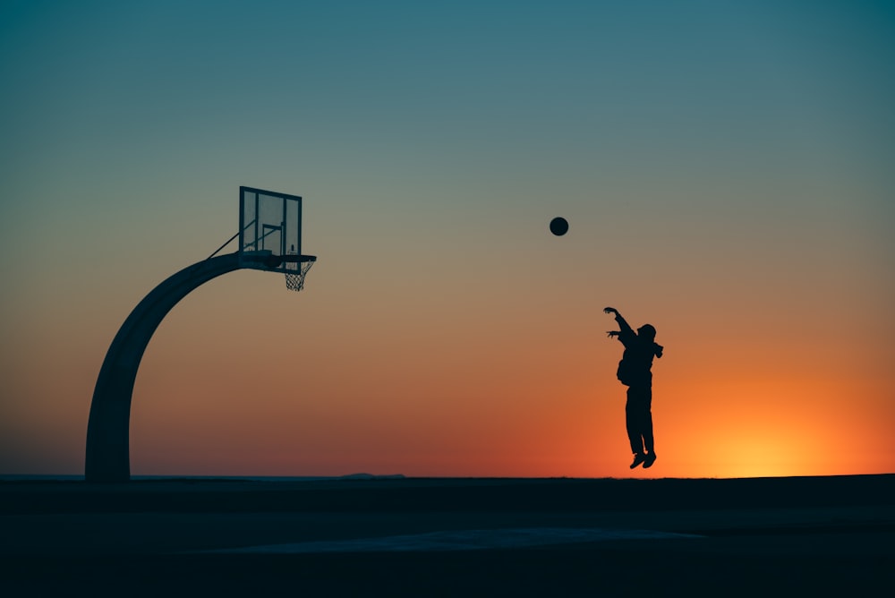 a person jumping in the air to catch a basketball