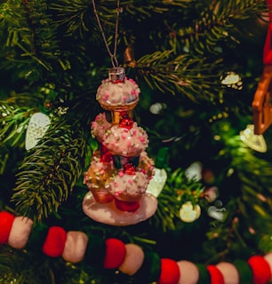 Festive holiday-themed cupcakes arranged like a Christmas tree, decorated with tiny edible ornaments.
