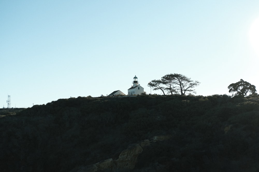 a church on a hill with trees in the background