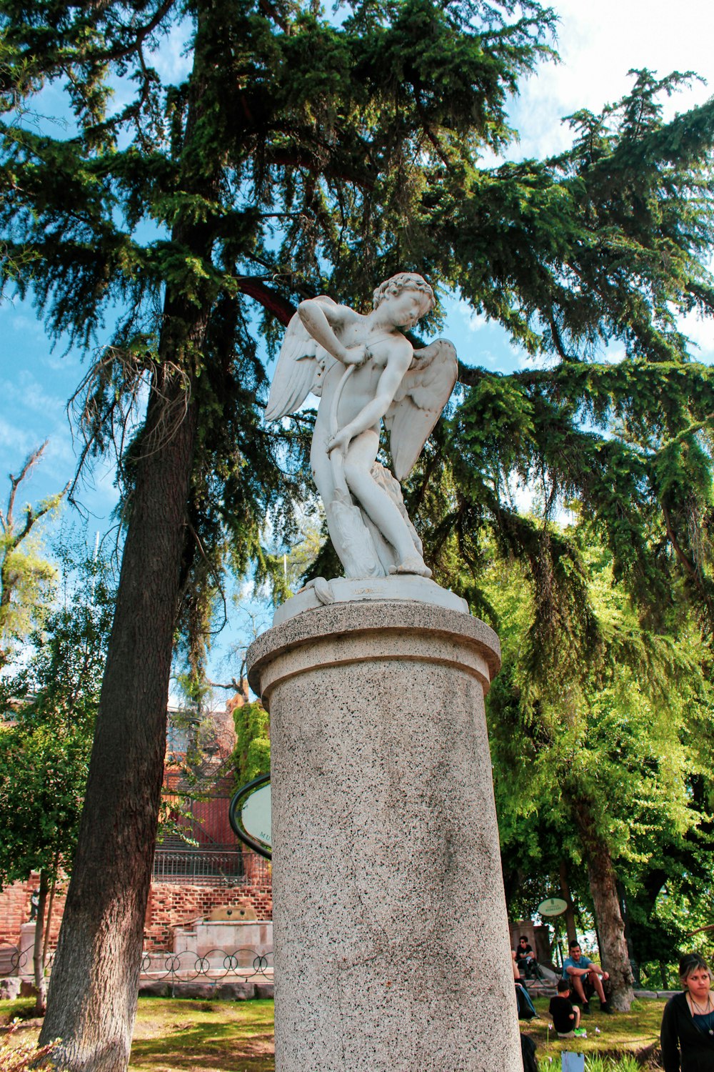 Eine Statue eines Mannes, der einen Baum in einem Park hält