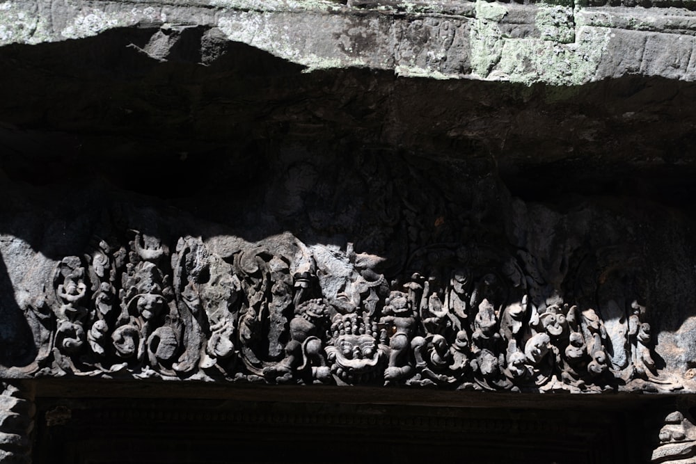 a group of statues sitting on top of a stone wall