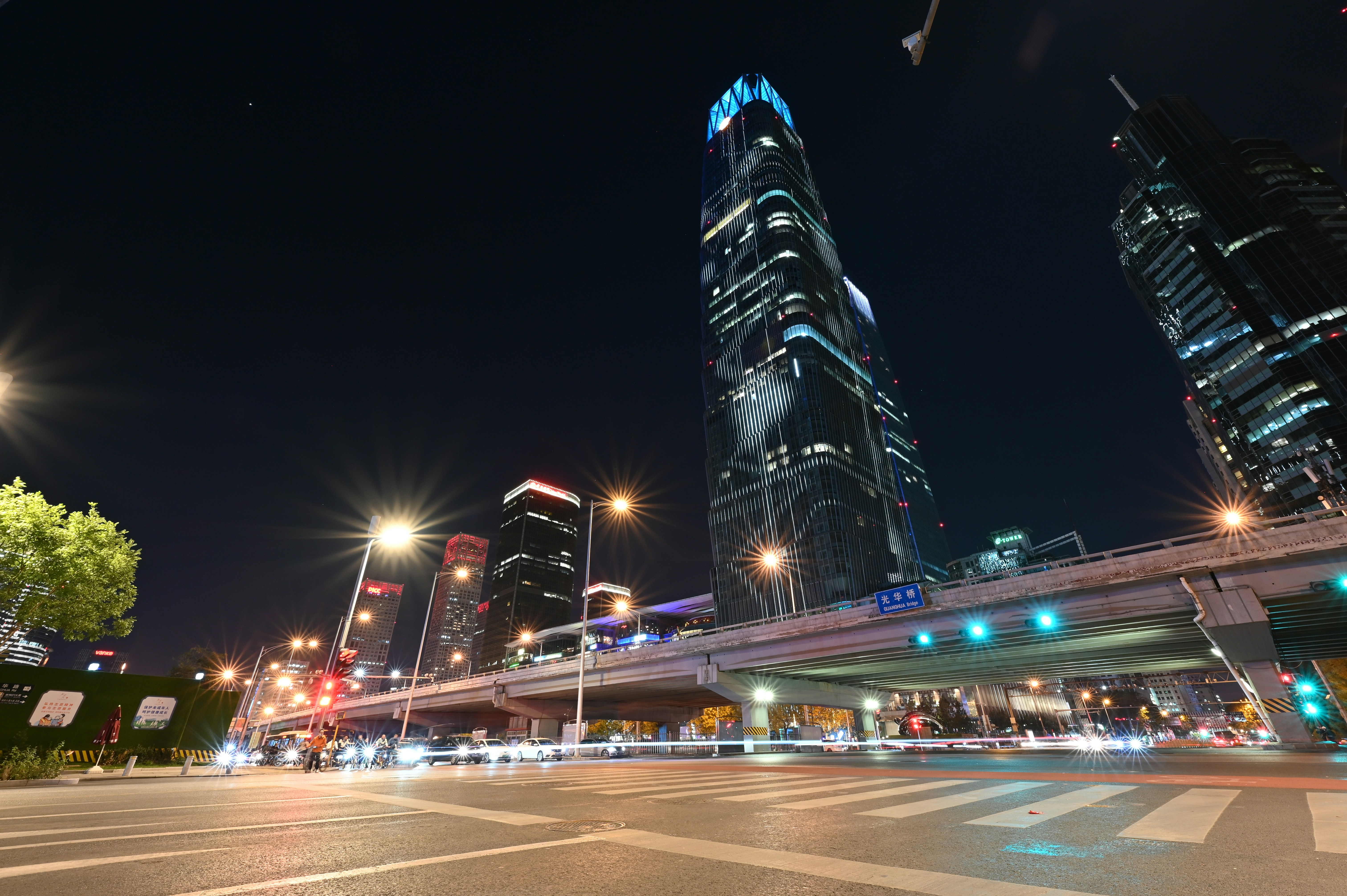 a city street at night with tall buildings