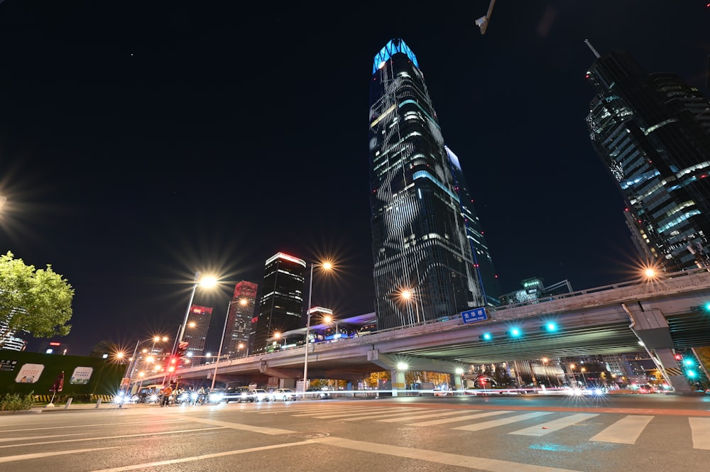 a city street at night with tall buildings