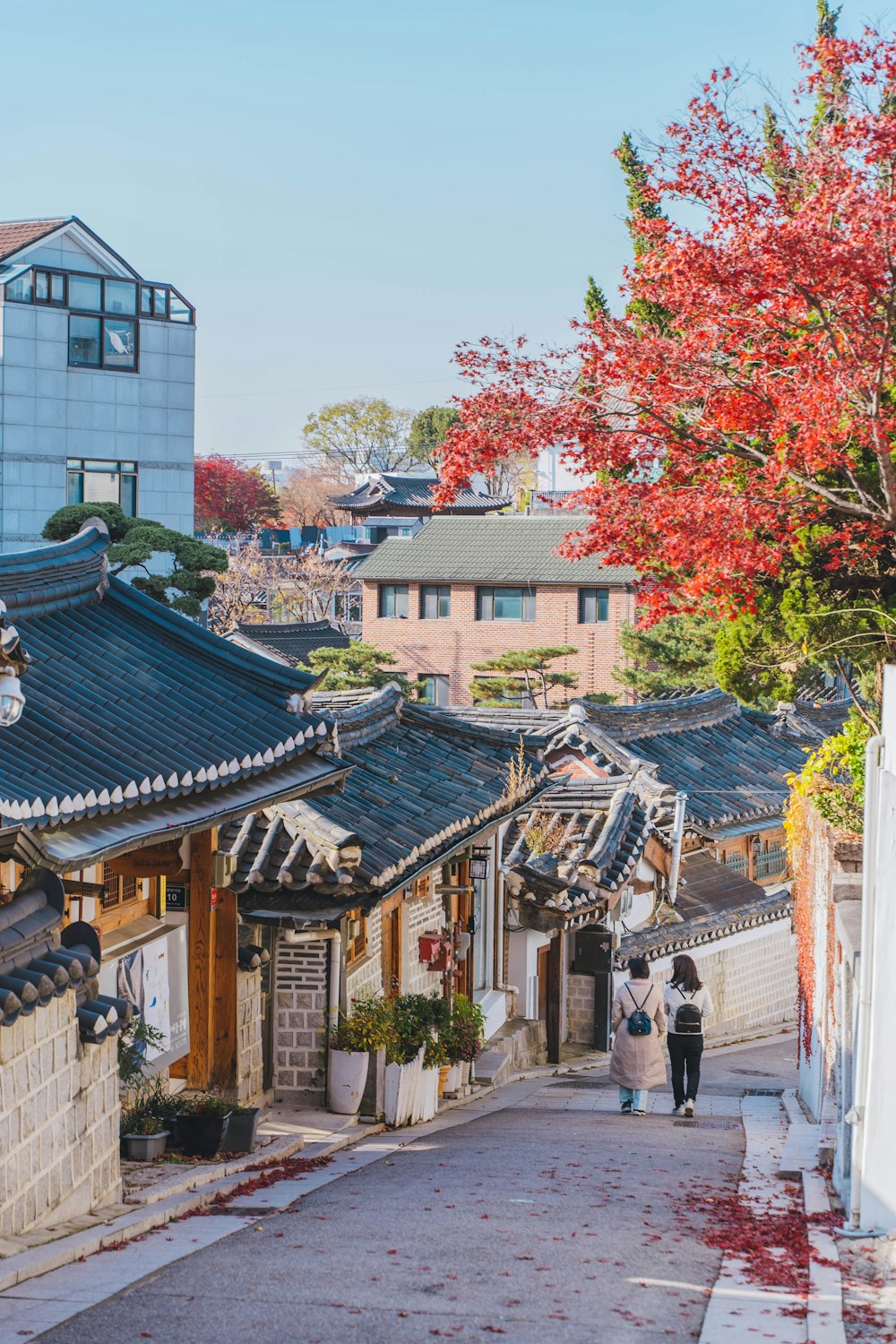 a couple of people walking down a street next to buildings