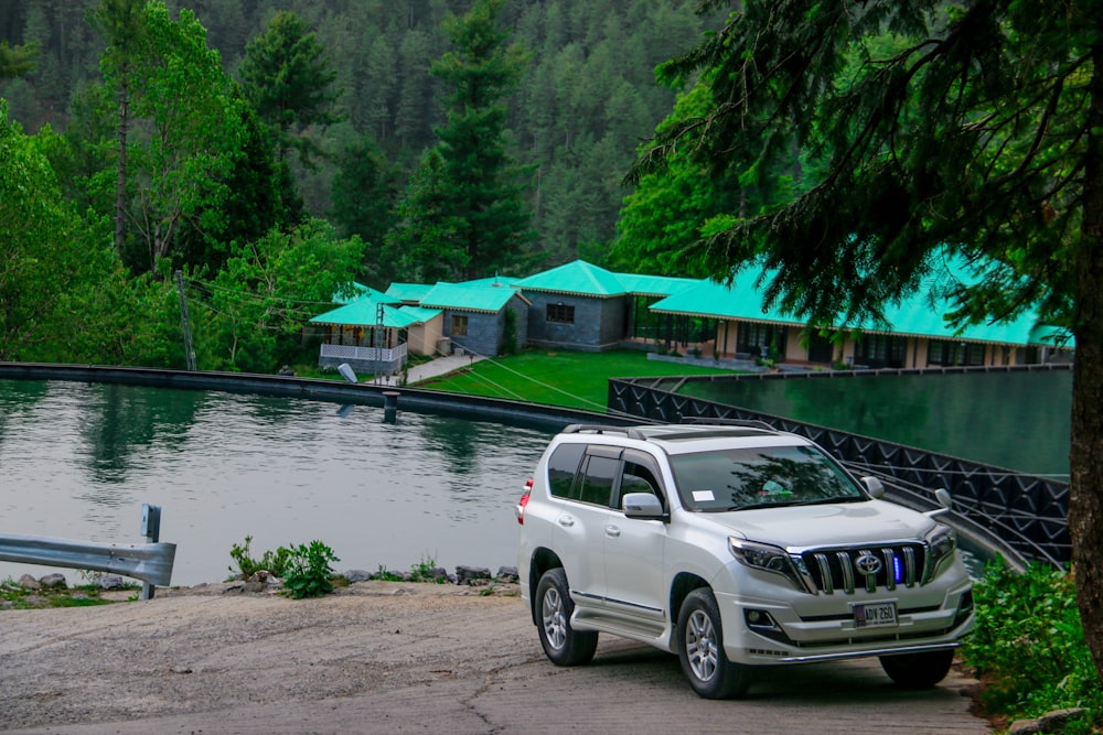 a white suv parked next to a body of water