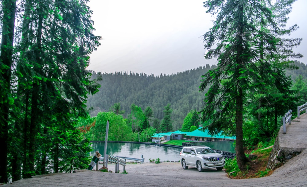 a car parked on the side of a road next to a lake