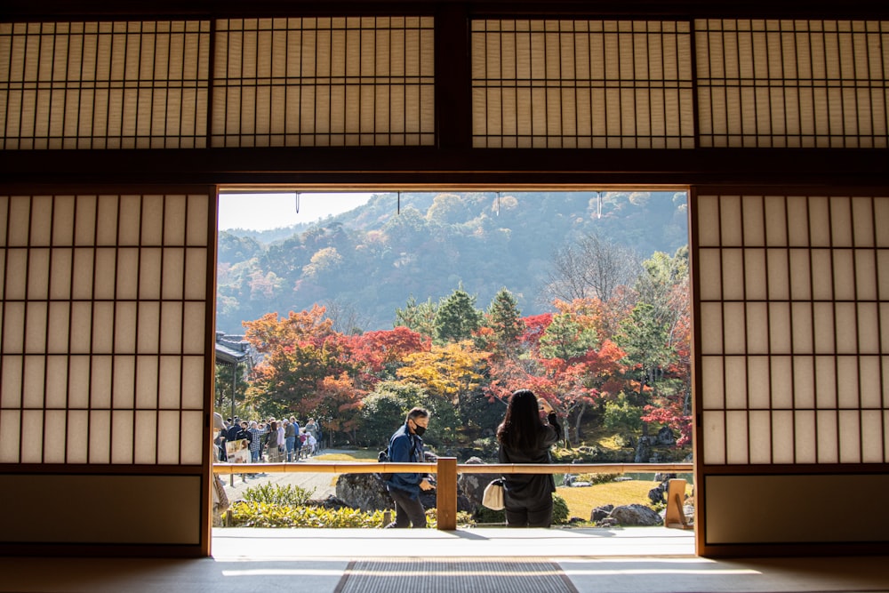 a couple of people that are standing in front of a window