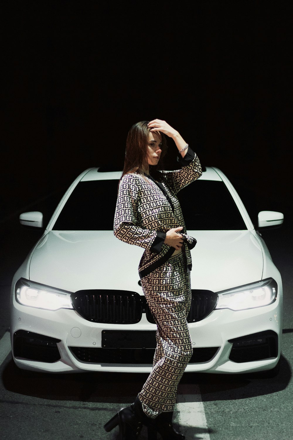 a woman standing in front of a white car