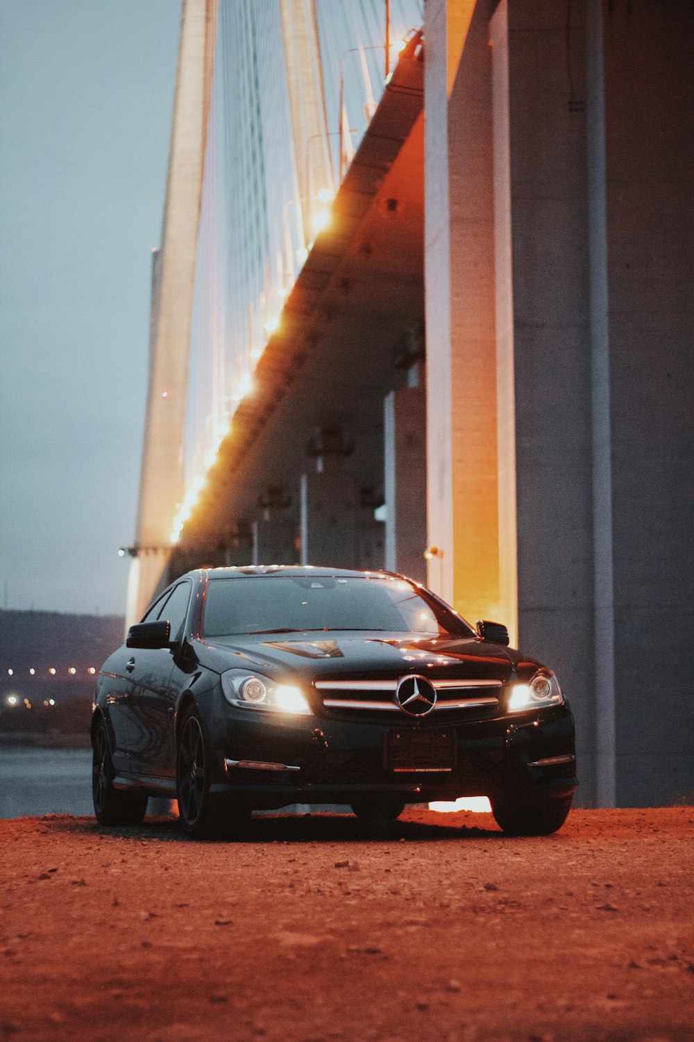 um carro preto estacionado em frente a uma ponte