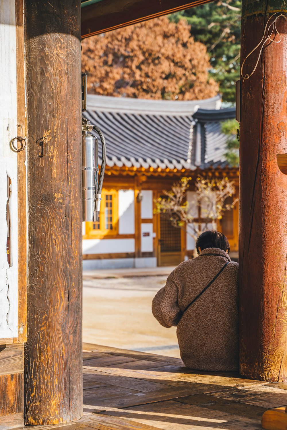 a person sitting on the ground in front of a building