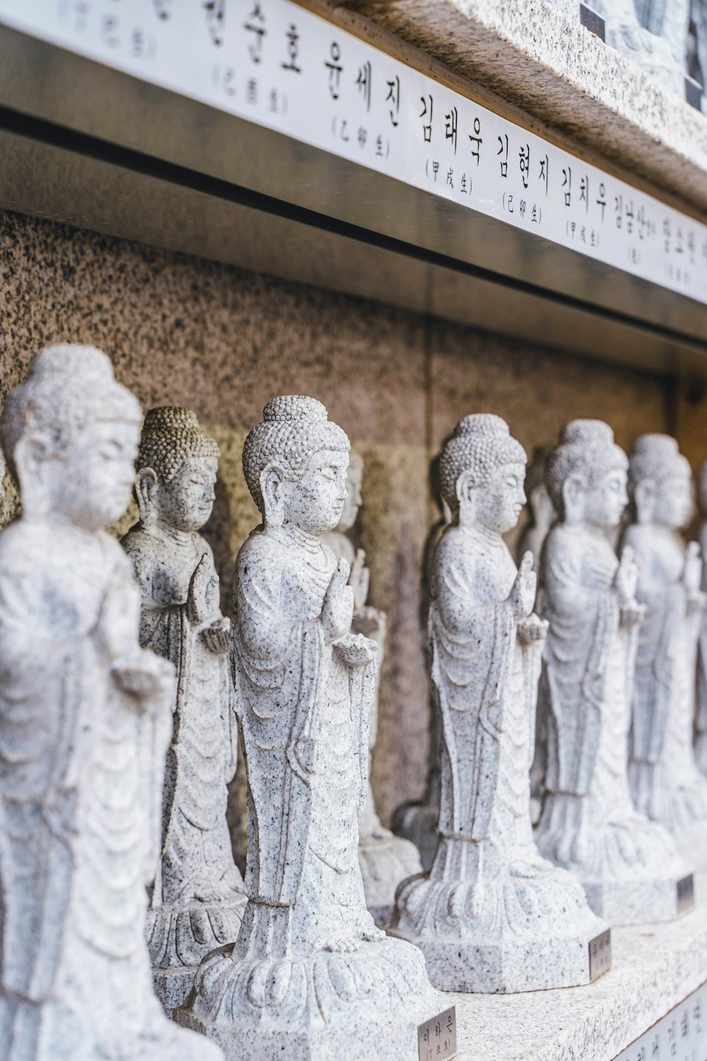 a group of statues sitting on top of a stone wall