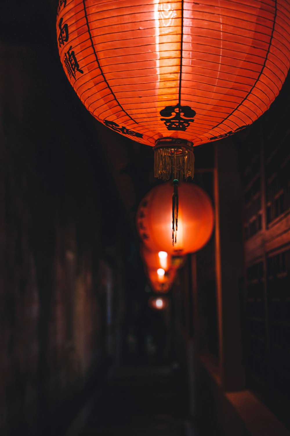 a couple of red lanterns hanging from a ceiling