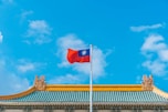 a red and blue flag on top of a building