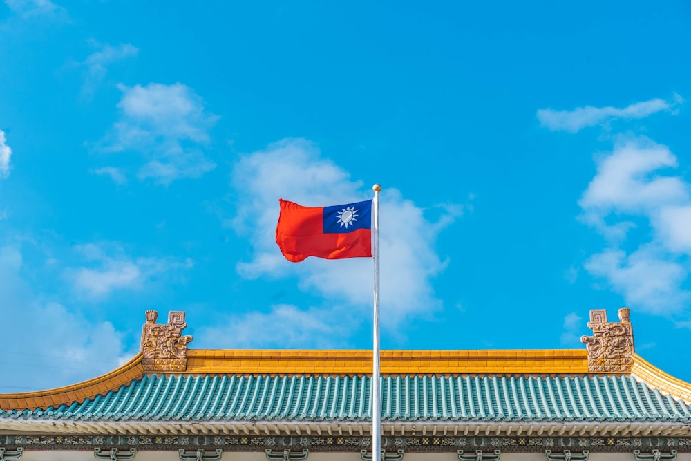 a red and blue flag on top of a building