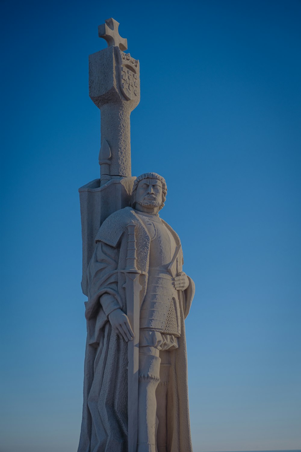 a statue of a man holding a cross