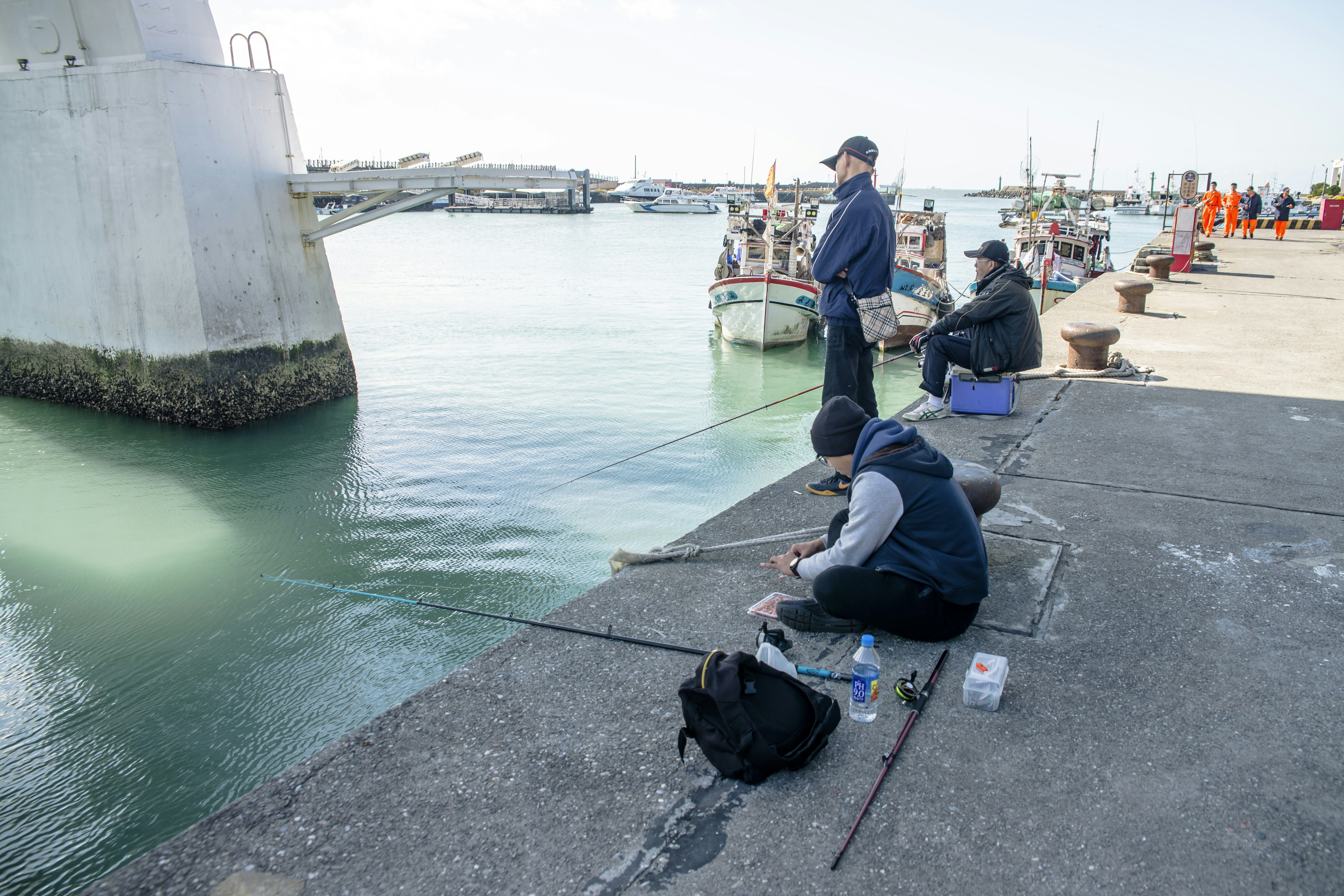 a group of people sitting on the side of a body of water