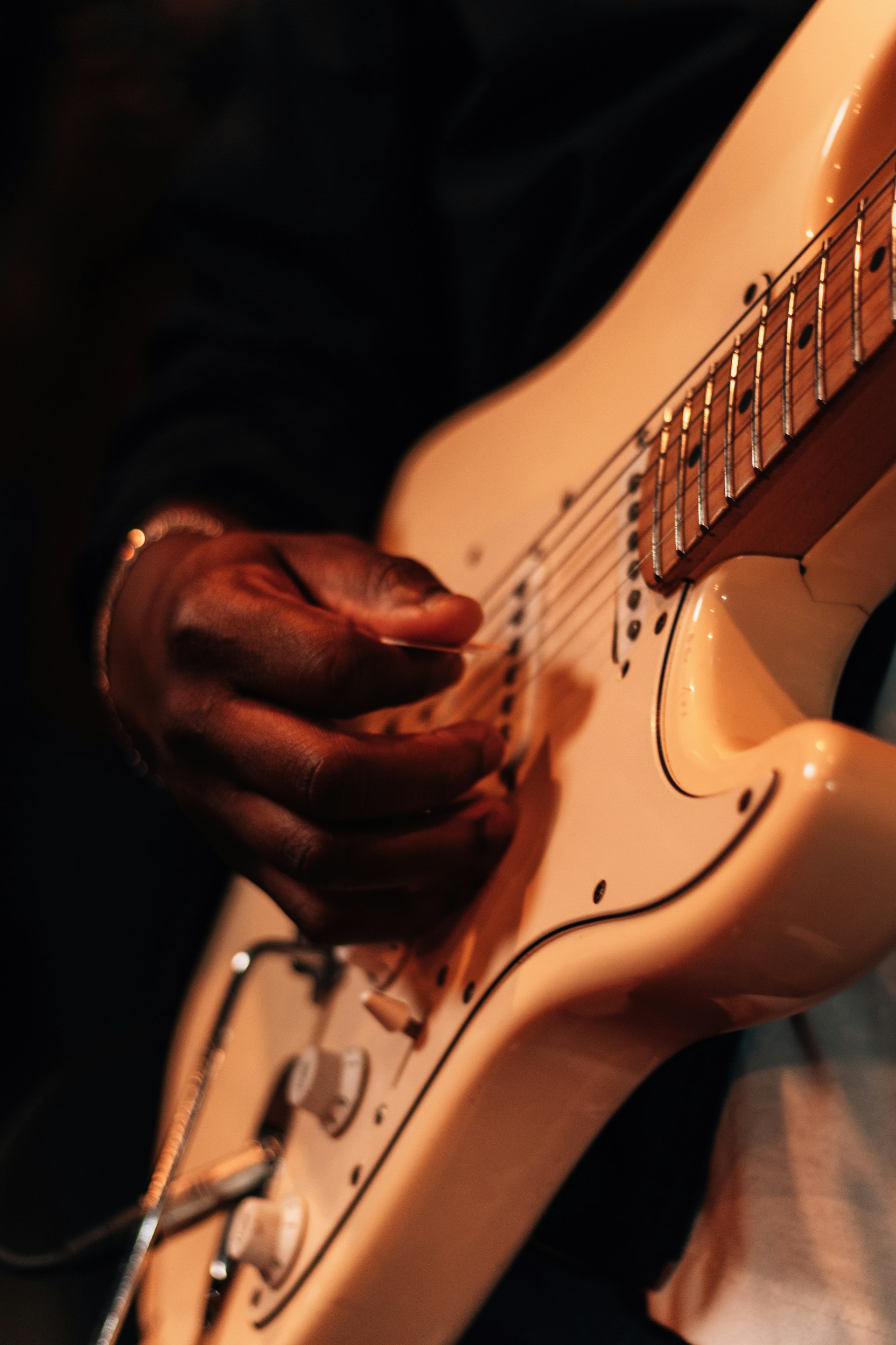 An intimate close-up of a musician passionately playing guitar, with warm lighting highlighting every detail.