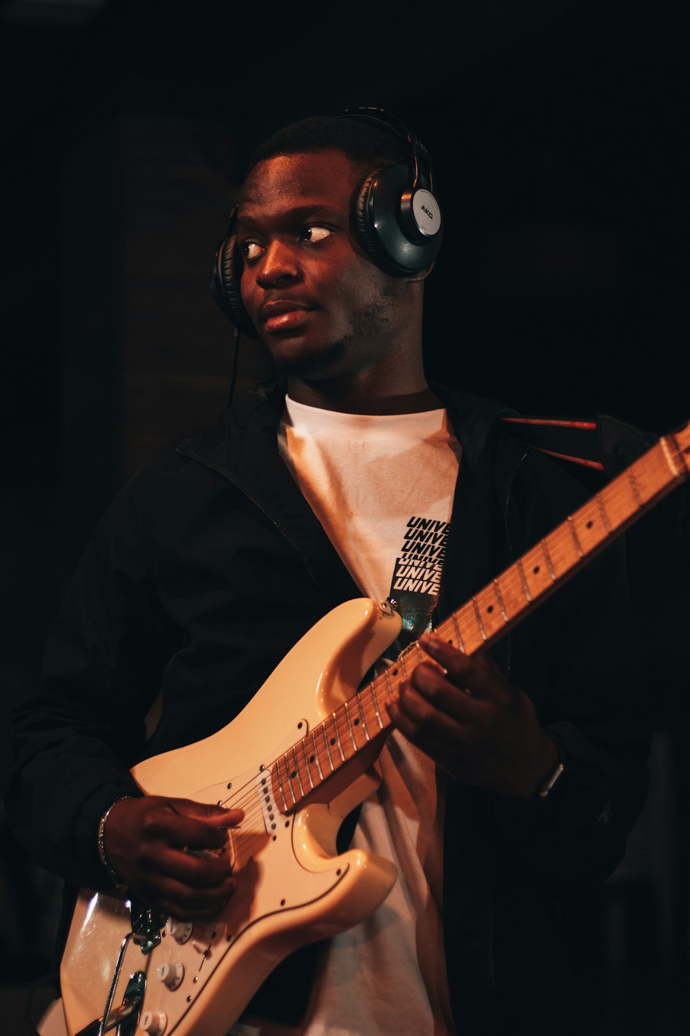 a man wearing headphones and playing a guitar