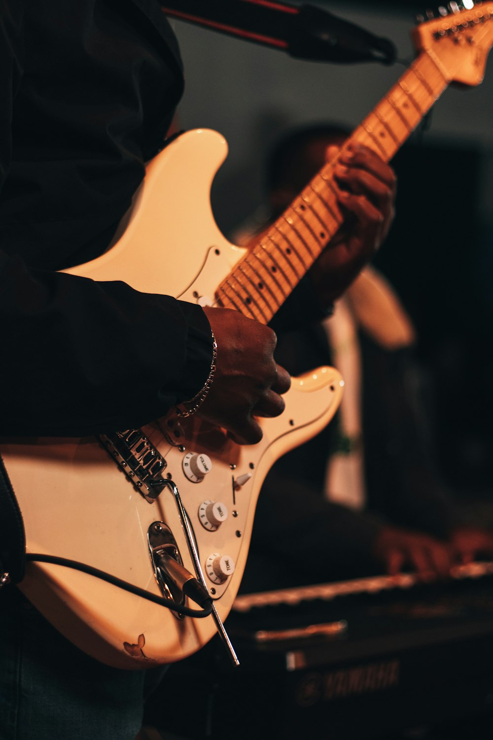 a person playing a guitar in front of a microphone