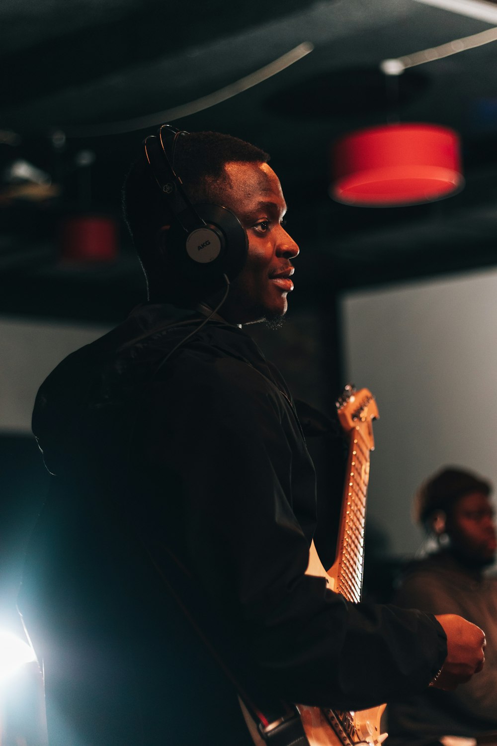 a man wearing headphones and holding a guitar