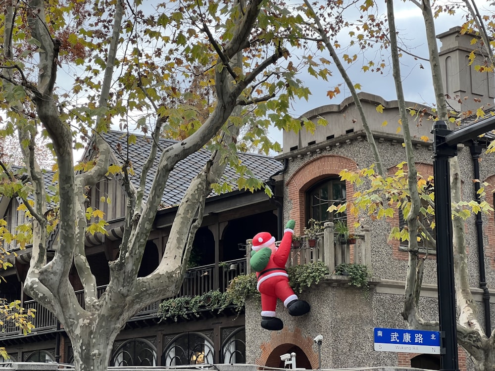 a giant inflatable santa clause hanging from a tree