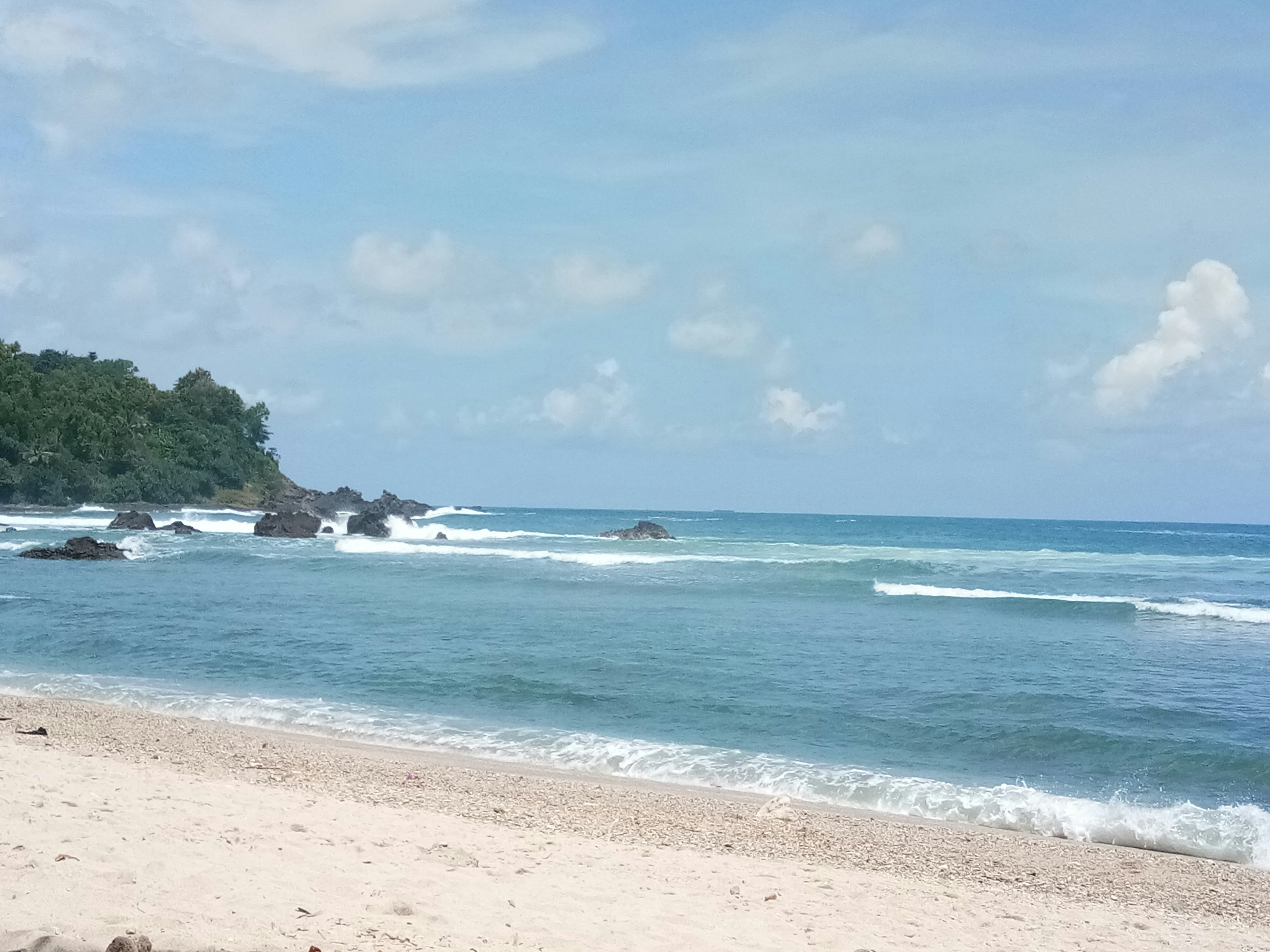 a sandy beach with waves coming in to shore