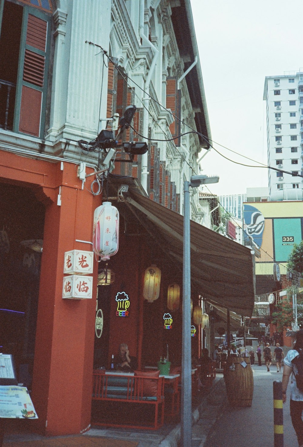 a person walking down a street next to a tall building