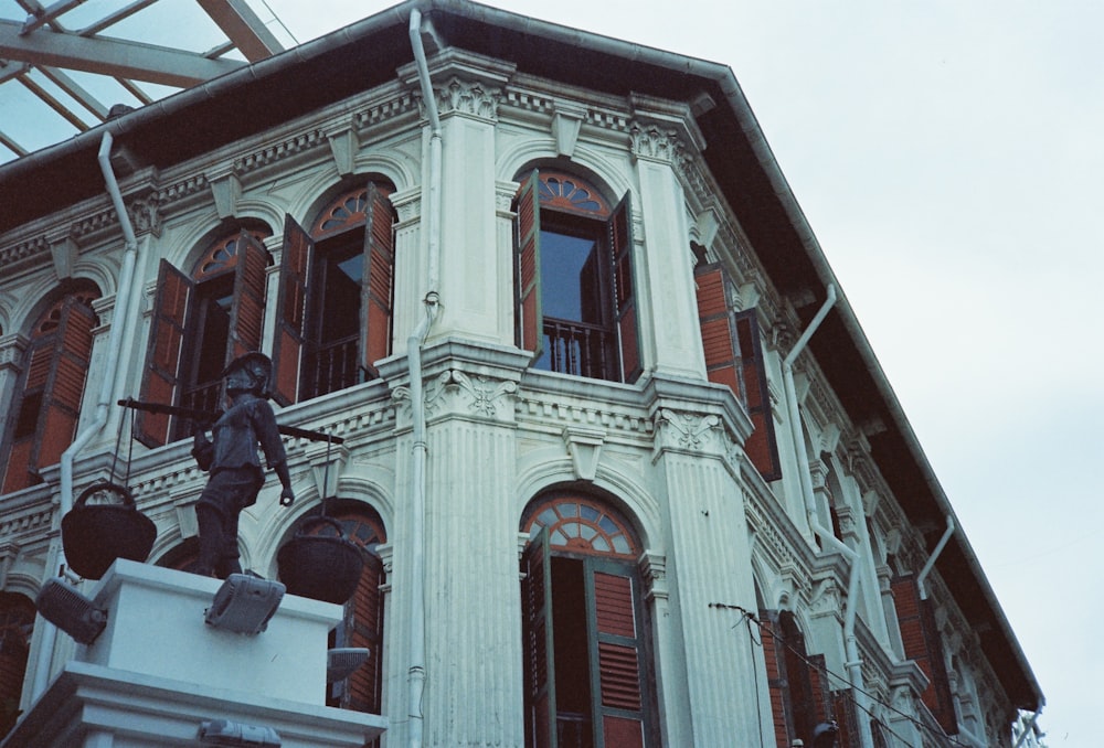 a tall white building with a statue on top of it