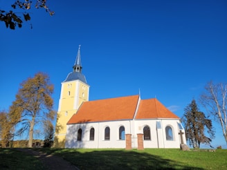 a white church with a red roof and a steeple